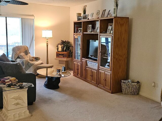 carpeted living room featuring ceiling fan