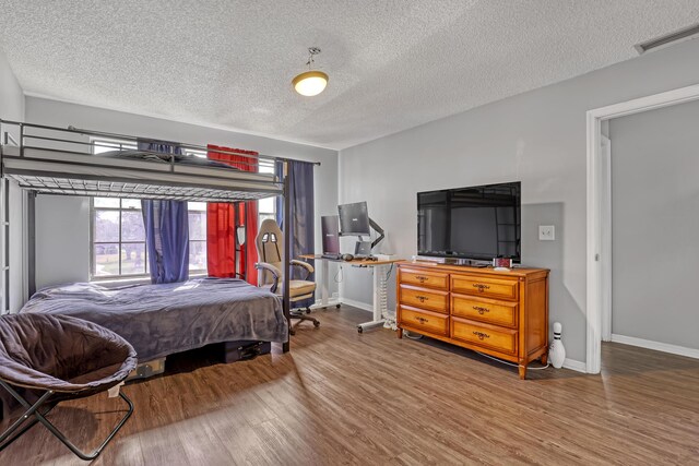 154 Weybridge Cir Unit C, Royal Palm Beach, FL 33411 - bedroom with visible vents, a textured ceiling, baseboards, and wood finished floors