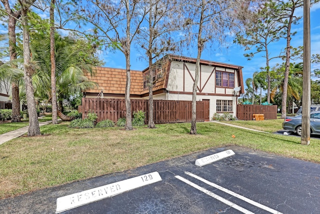 154 Weybridge Cir Unit C, Royal Palm Beach, FL 33411 - view of side of home with stucco siding, uncovered parking, fence, and a yard