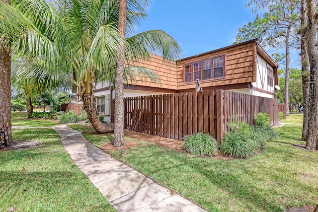 154 Weybridge Cir Unit C, Royal Palm Beach, FL 33411 - view of property exterior featuring fence, mansard roof, and a yard