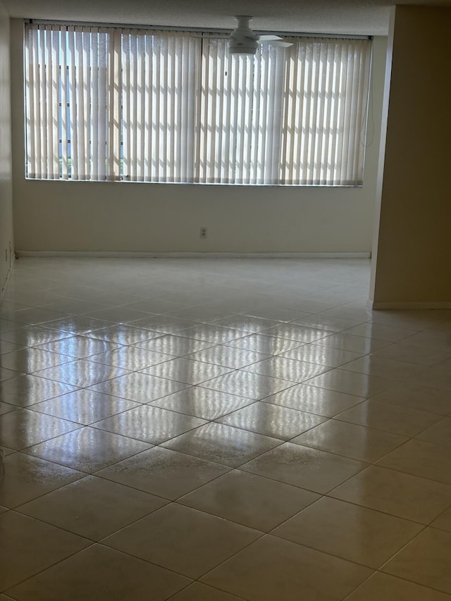 unfurnished room with ceiling fan and tile patterned flooring