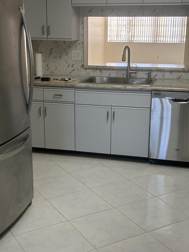 kitchen featuring light countertops, appliances with stainless steel finishes, backsplash, and a sink