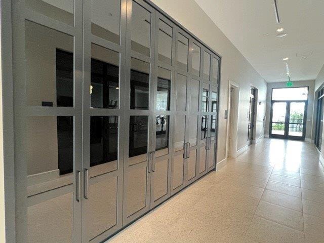 corridor featuring french doors and baseboards