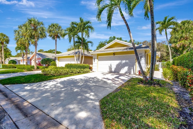 single story home with driveway, a front yard, a garage, and stucco siding