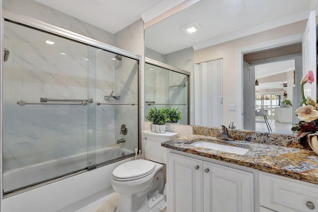 full bath featuring enclosed tub / shower combo, vanity, and toilet