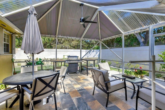 view of patio / terrace with outdoor dining space, a lanai, ceiling fan, and area for grilling