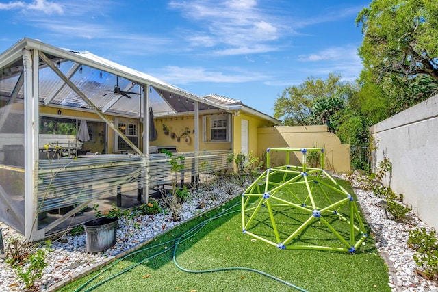 view of yard featuring glass enclosure and a fenced backyard