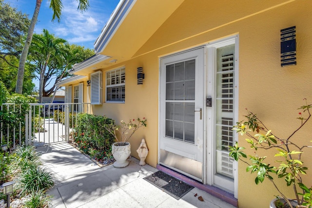 property entrance featuring a gate and stucco siding