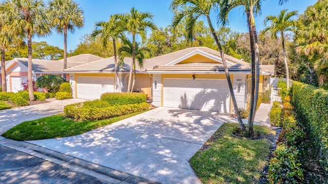 ranch-style home with a garage, driveway, fence, and stucco siding