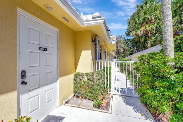 property entrance with a gate and stucco siding