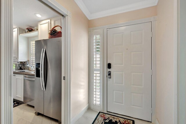 entrance foyer featuring ornamental molding, marble finish floor, and a healthy amount of sunlight