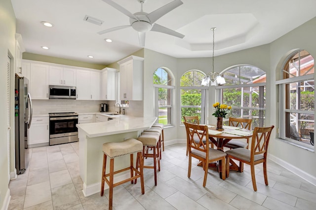 kitchen with tasteful backsplash, visible vents, appliances with stainless steel finishes, a sink, and a peninsula