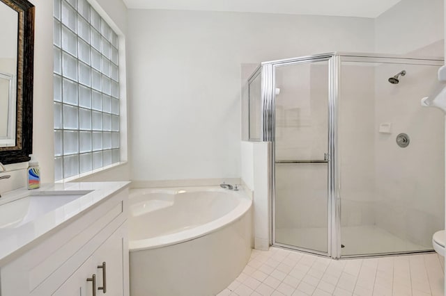 bathroom with a stall shower, vanity, toilet, and a bath