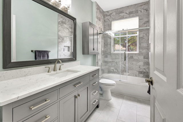 bathroom featuring toilet, shower / bath combination with glass door, tile patterned floors, and vanity