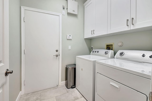 washroom with cabinet space, baseboards, separate washer and dryer, and light tile patterned flooring