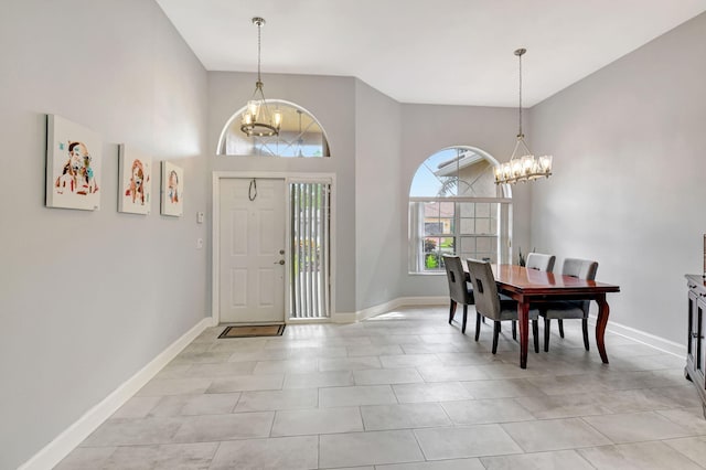 entryway featuring a chandelier, a high ceiling, and baseboards