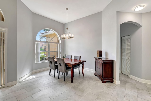 dining space featuring a chandelier and baseboards