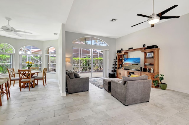 living room featuring ceiling fan with notable chandelier, visible vents, and baseboards