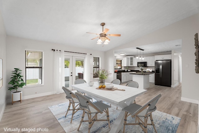 dining room with french doors, baseboards, light wood-style floors, and vaulted ceiling