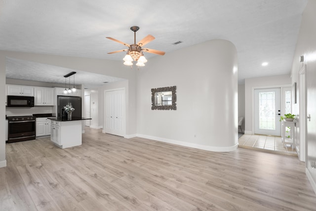 kitchen featuring visible vents, light wood-style flooring, white cabinets, appliances with stainless steel finishes, and dark countertops