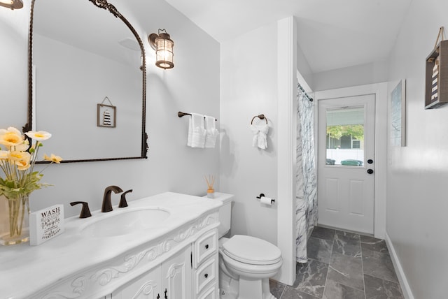 bathroom featuring vanity, a shower with shower curtain, toilet, and baseboards