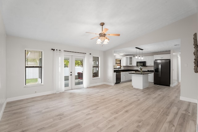 unfurnished living room with light wood finished floors, french doors, baseboards, and lofted ceiling