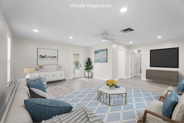 living room with visible vents, baseboards, recessed lighting, light wood-style floors, and a ceiling fan