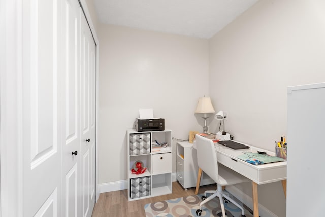 home office with light wood-type flooring and baseboards