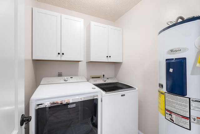 clothes washing area with cabinet space, washer and dryer, electric water heater, and a textured ceiling