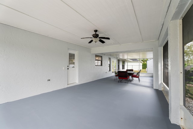 unfurnished sunroom featuring a ceiling fan