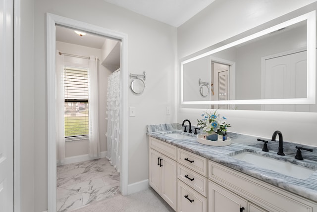361 SW Carter Ave, Port Saint Lucie, FL 34983 - bathroom with marble look tiles, double vanity, and baseboards