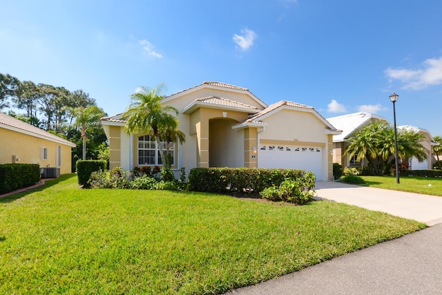 mediterranean / spanish-style house with a tile roof, stucco siding, concrete driveway, an attached garage, and a front yard