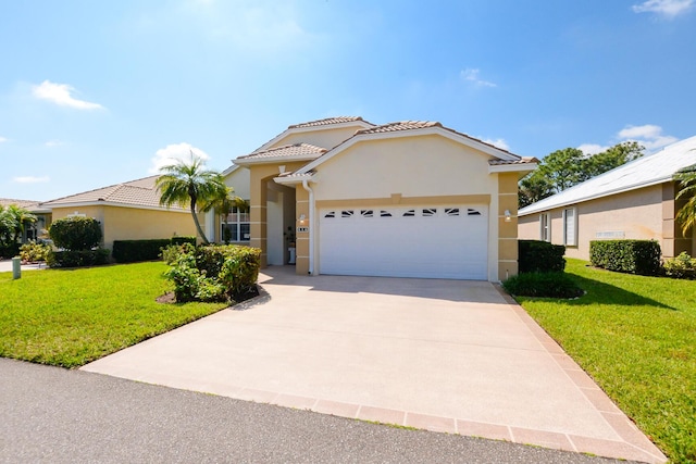 mediterranean / spanish-style house with a front lawn, driveway, an attached garage, and stucco siding