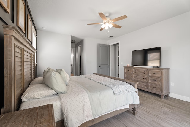 bedroom featuring visible vents, light wood-style flooring, a ceiling fan, and baseboards