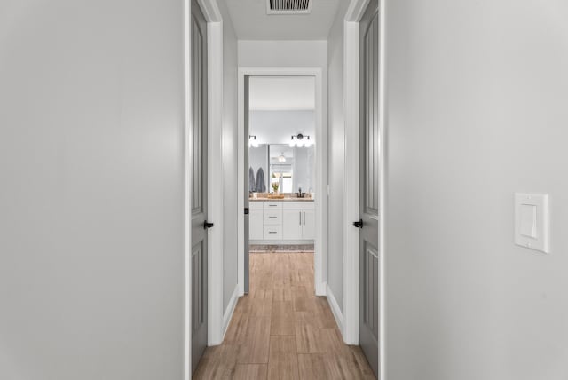 corridor featuring visible vents and light wood-style floors