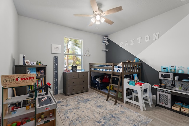 bedroom with a ceiling fan, vaulted ceiling, wood finished floors, and baseboards