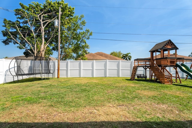 view of yard with a fenced backyard, a playground, and a trampoline