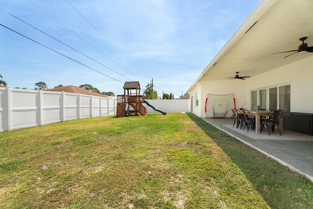 view of yard featuring a patio, a fenced backyard, a ceiling fan, and a playground