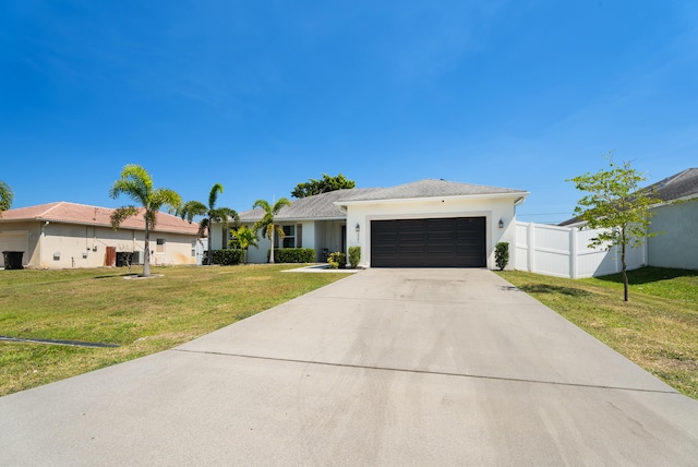 ranch-style home featuring a front lawn, fence, concrete driveway, stucco siding, and a garage