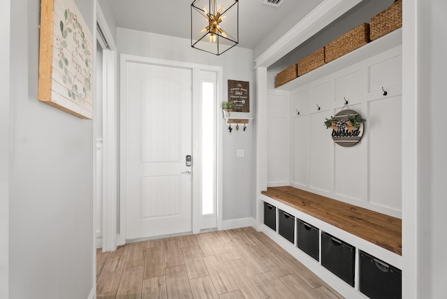 mudroom with a chandelier, visible vents, light wood-type flooring, and baseboards