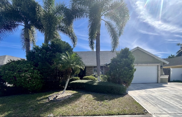 view of front of property with a garage, a front yard, driveway, and stucco siding