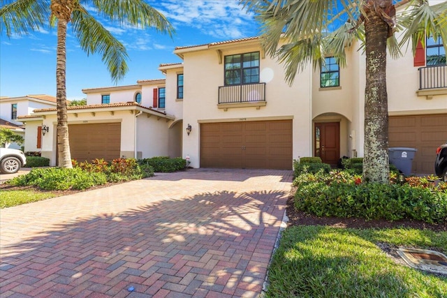 mediterranean / spanish house with a tiled roof, decorative driveway, and stucco siding