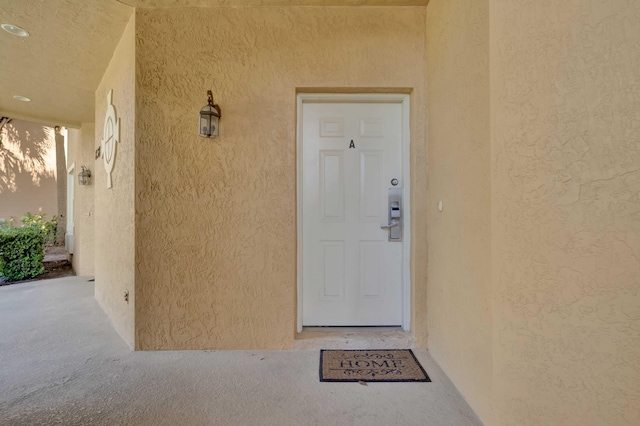 doorway to property featuring stucco siding