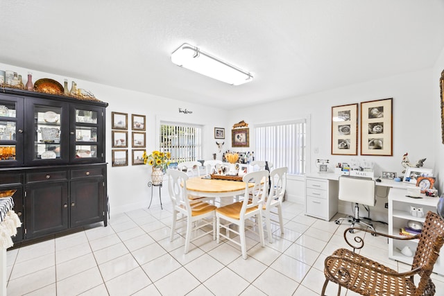 dining area featuring light tile patterned floors and baseboards