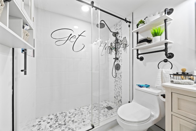 bathroom with a shower stall, toilet, and vanity