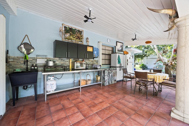 view of patio with outdoor dining area, an outdoor kitchen, a sink, and a ceiling fan