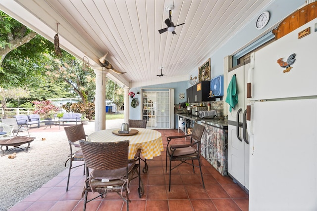 view of patio featuring ceiling fan, outdoor dining area, and outdoor wet bar