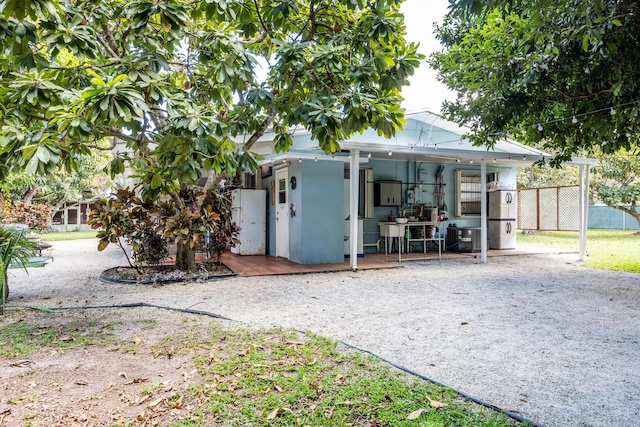 rear view of house with fence and stucco siding