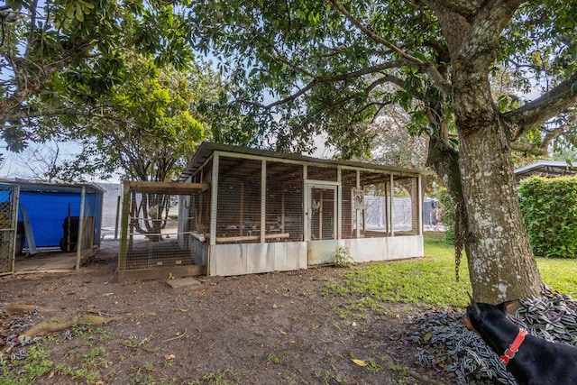 back of house featuring exterior structure and an outdoor structure