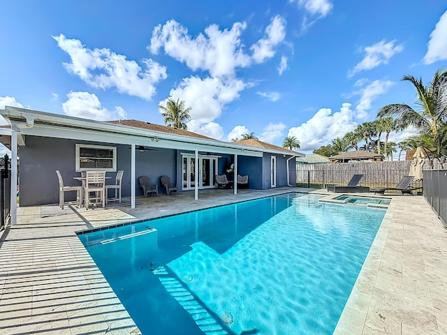 view of pool featuring a patio, a pool with connected hot tub, a fenced backyard, and a ceiling fan